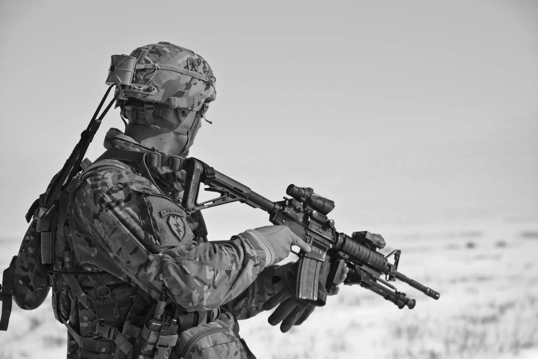 A black-and-white photo of a soldier in military uniform holding a rifle.