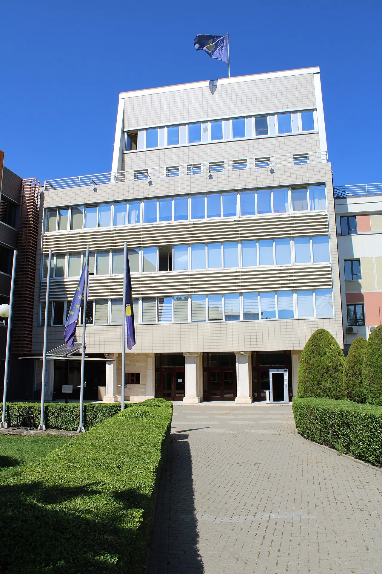 Bygningen for Kosovos parlament ses her i et arkitektonisk perspektiv. Billedet fremhæver institutionens facade og placering i Pristina.