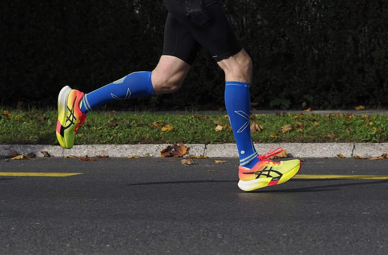 Et øjebliksbillede af en maratonløbers løbegang fra terminal swing til hælanslag (initial contact). Løberen bærer Asics Metaspeed Edge “Paris” under 2024 Ljubljana Marathon.