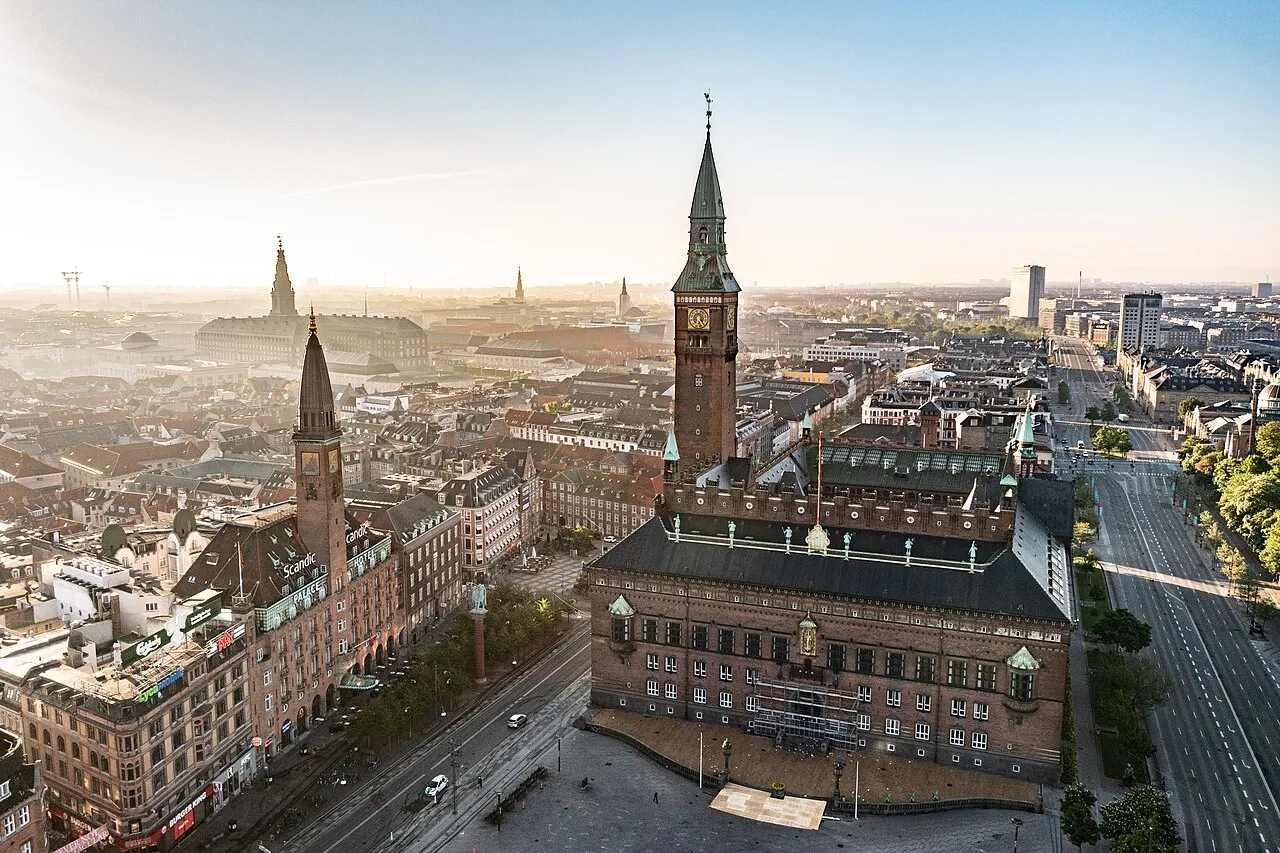 Et bredt udsyn til Københavns Rådhus på Rådhuspladsen med historiske omgivelser. Billedet fremhæver bygningens monumentale fremtoning.