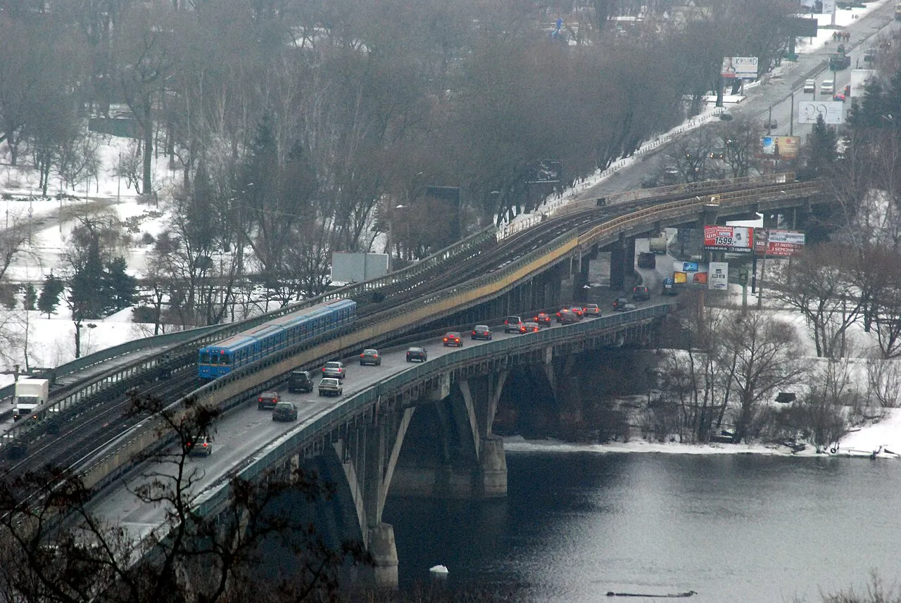 Et metro-tog krydser Dnipro via Metrobroen i Kyiv. Billedet er taget fra området ved Kiev-Pechersk Lavra.