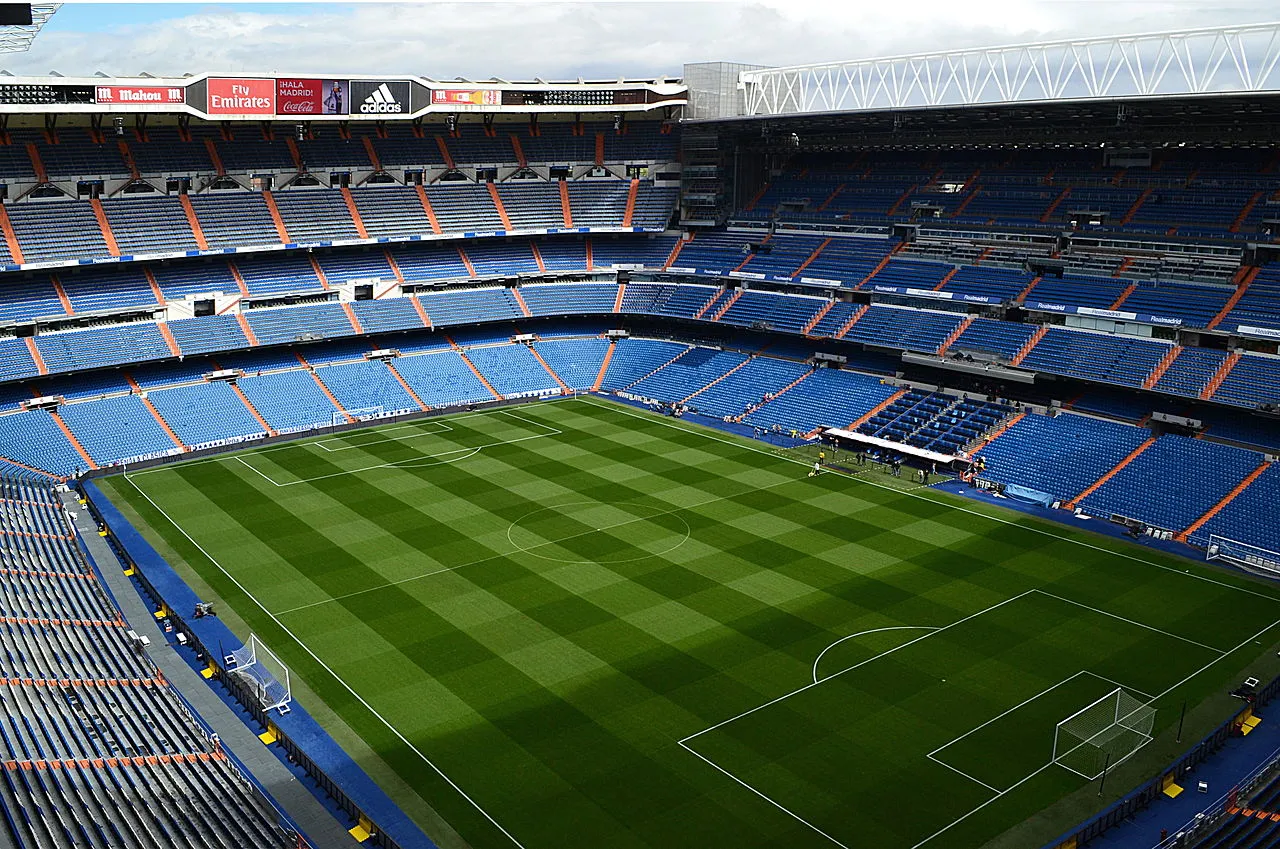 Et bredt panoramabillede af Santiago Bernabéu Stadion i Madrid. Perspektivet viser stadionets samlede form og den markante placering i byens sportslandskab.