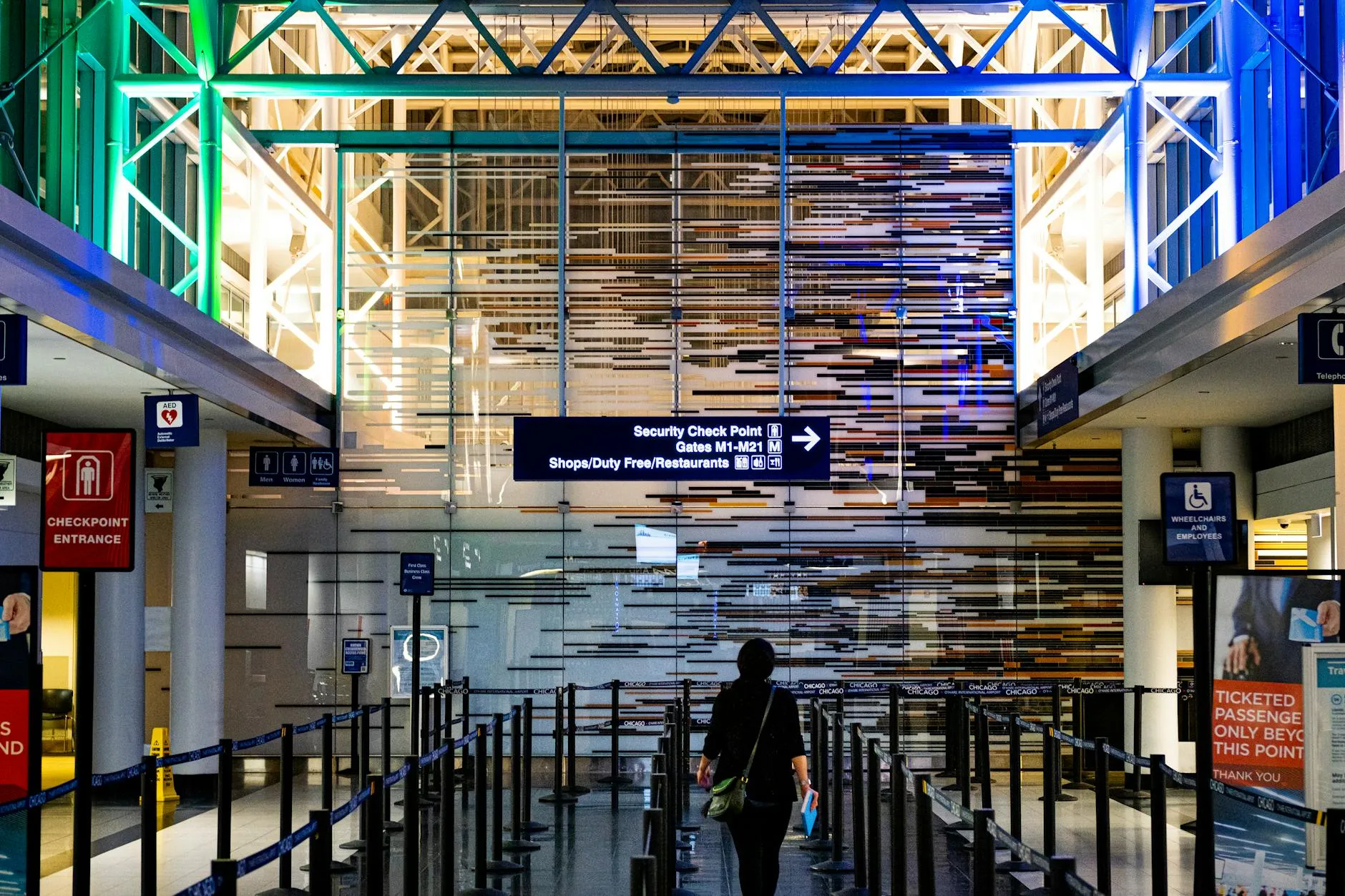 En rejsende bevæger sig ind i sikkerhedskontrollen i O'Hare Lufthavn i Chicago. Scenen viser lufthavnsflowet og den travle rejseoplevelse.