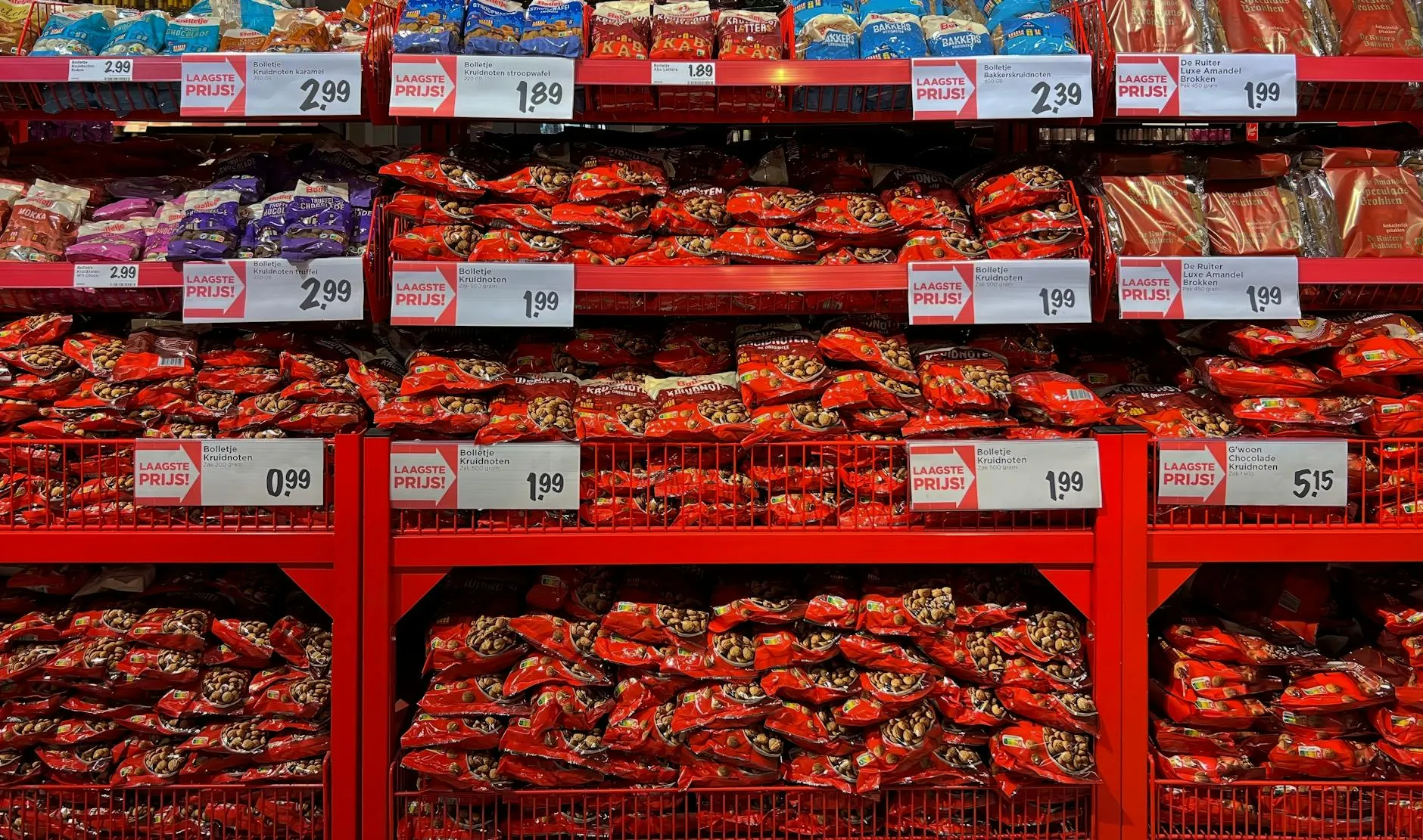 En farverig fremvisning af slikposer i en supermarket. Billedet viser tydelige pris-/kampagneelementer og et livligt udvalg af slik.