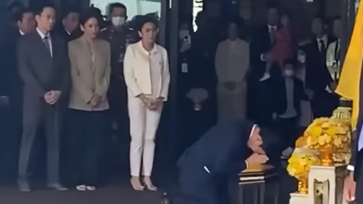 Thaksin Shinawatra betragter og hylder et kongeligt portræt af Kong Vajiralongkorn og Dronning Suthida ved Don Mueang International Airport. Billedet er taget efter hans tilbagevenden til Thailand efter 15 års eksil.