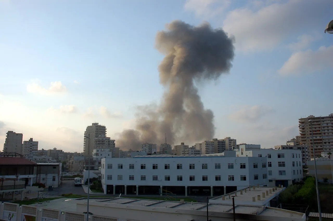 Der ses støv og røg efter nedslag fra to 500 lb (230 kg) laserstyrede bomber under et israelsk luftangreb på Tyre i Libanon. Fotoet illustrerer ødelæggelserne i området efter angrebet.