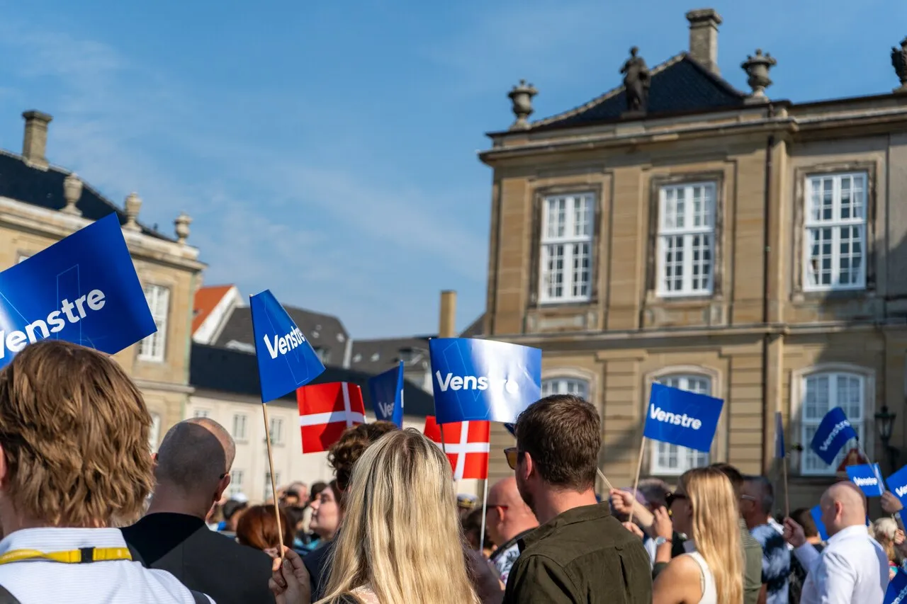 Venstre-supportere løfter Venstre-flag på Amalienborg Slotsplads efter ændringer i den danske regering blev officielt annonceret 29. august 2024.