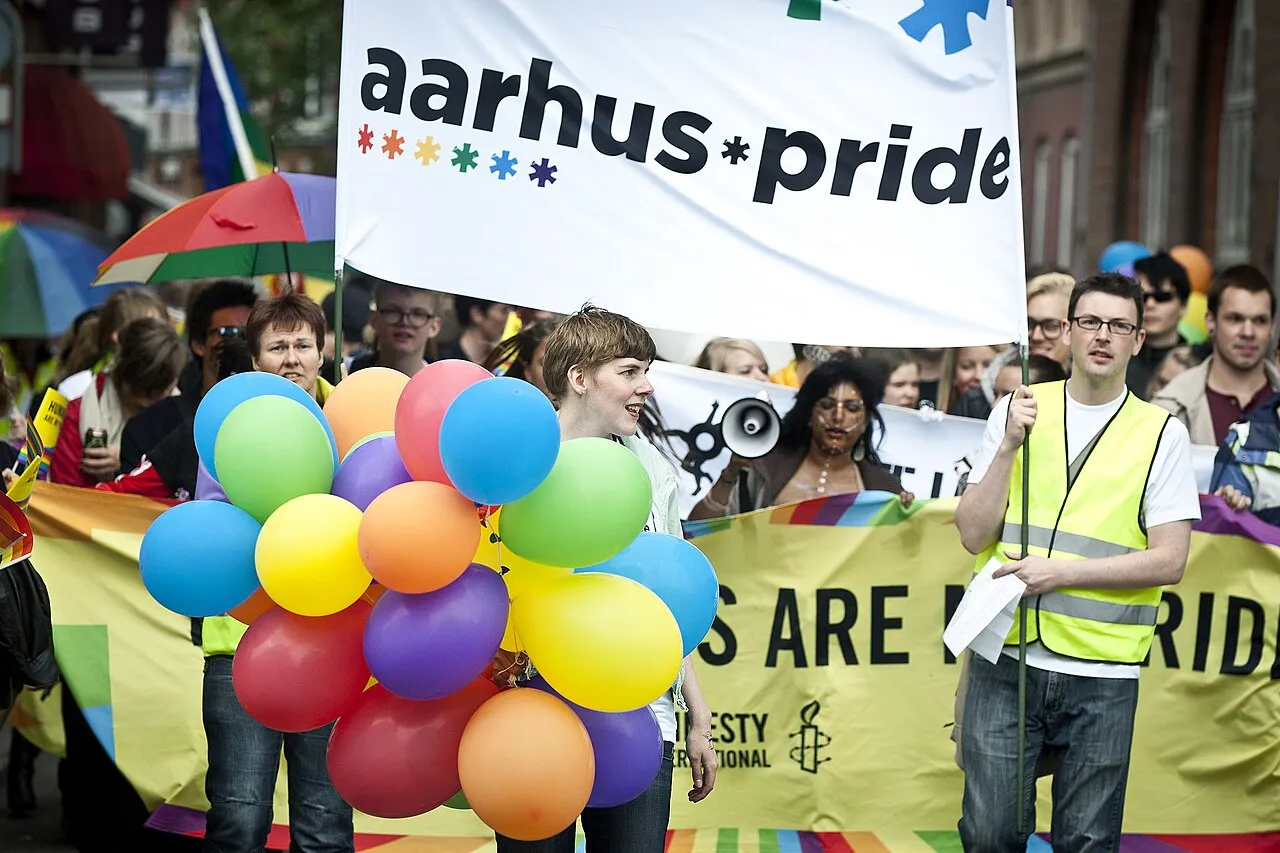 Deltagere marcherer under Aarhus Pride i 2012. Billedet indfanger bevægelse, energi og fællesskab i byens gader.