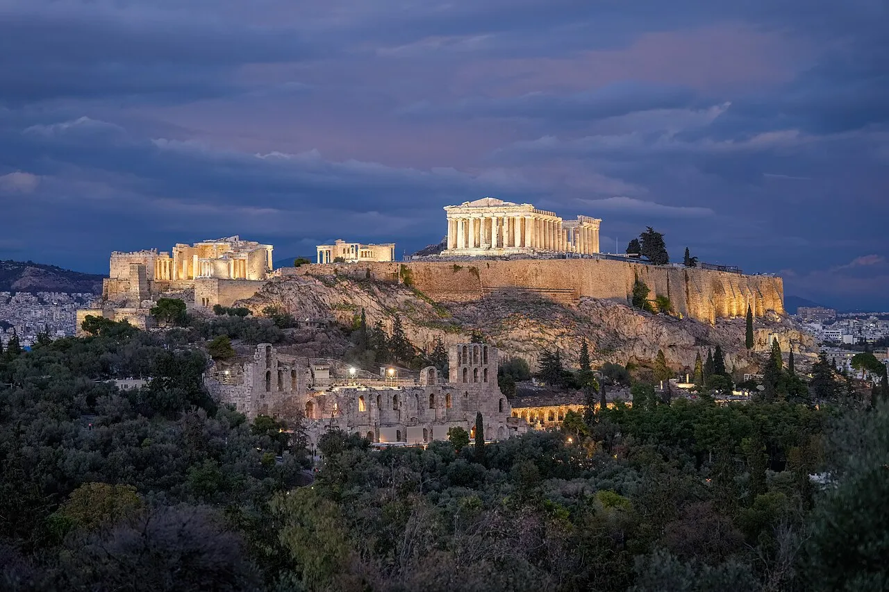 Akropolis i Athen oplyst om natten. Et stemningsfuldt billede af det historiske vartegn i mørke.