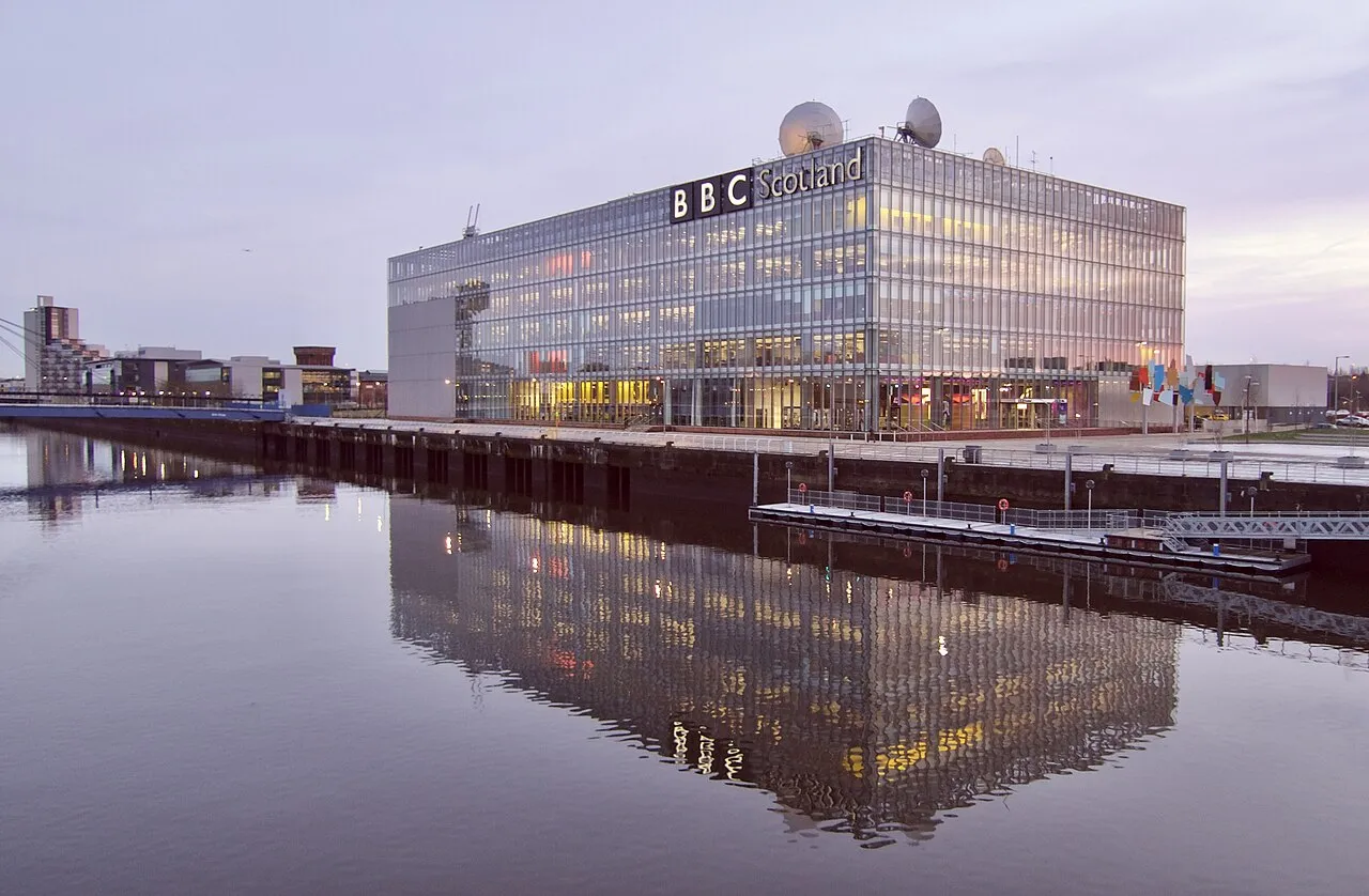 BBC’s hovedkvarter i London, som er et ikonisk vartegn i Storbritanniens medielandskab. Billedet viser bygningen i bymiljøet.
