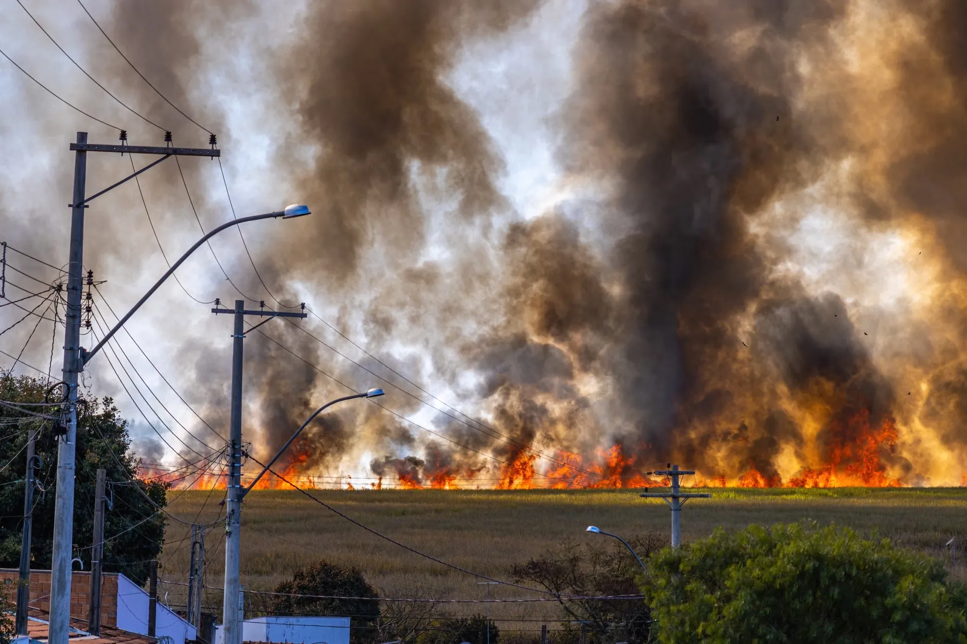 Et landskab med en brand, hvor røgen stiger op under en klar himmel.