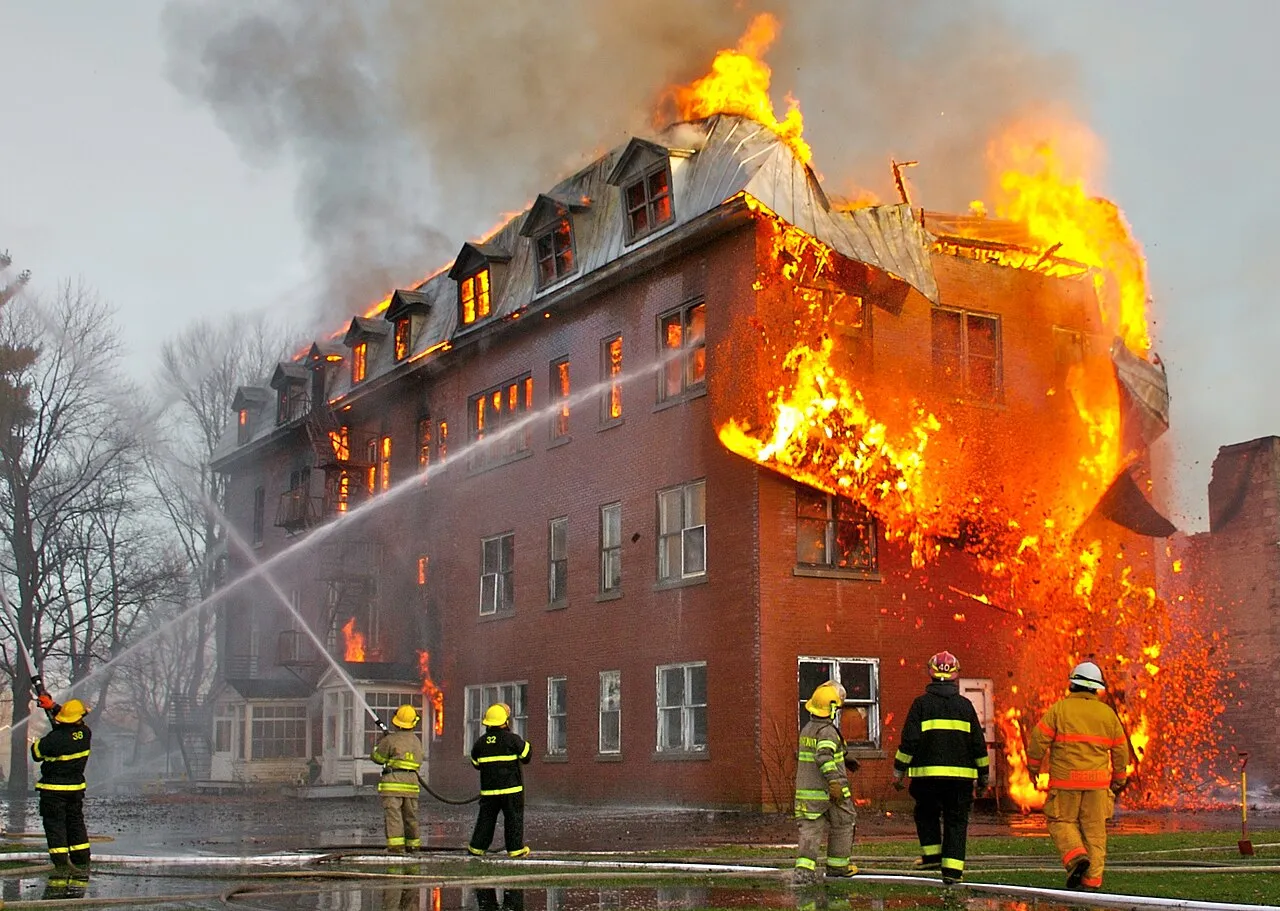 Et dramatisk foto af en stor brand inde i et forladt kloster i Massueville, Quebec, Canada. Billedet viser flammernes intensitet og den særlige vinkel fra brandfotografering.