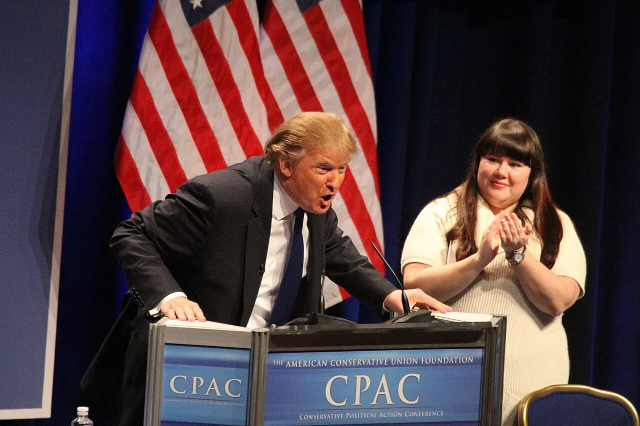 Donald Trump står på talerstolen under CPAC i 2011. Billedet viser ham sammen med Lisa De Pasquale under arrangementets første dag.