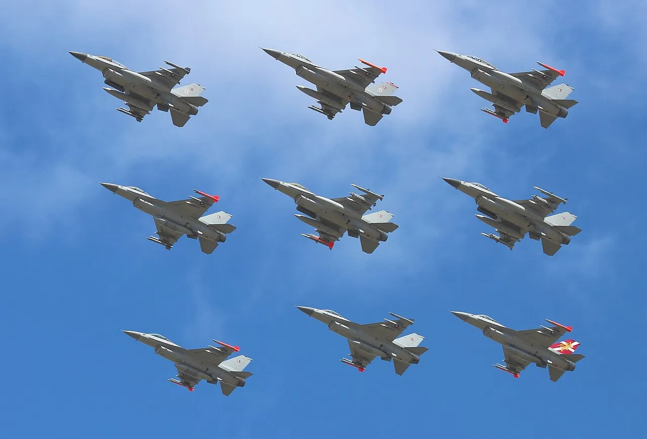 Ni F-16-fly fra Royal Danish Air Force flyver i diamantformation under Danish Air Show 2014. Billedet fanger flyenes opvisningsopsætning og formation i luften.
