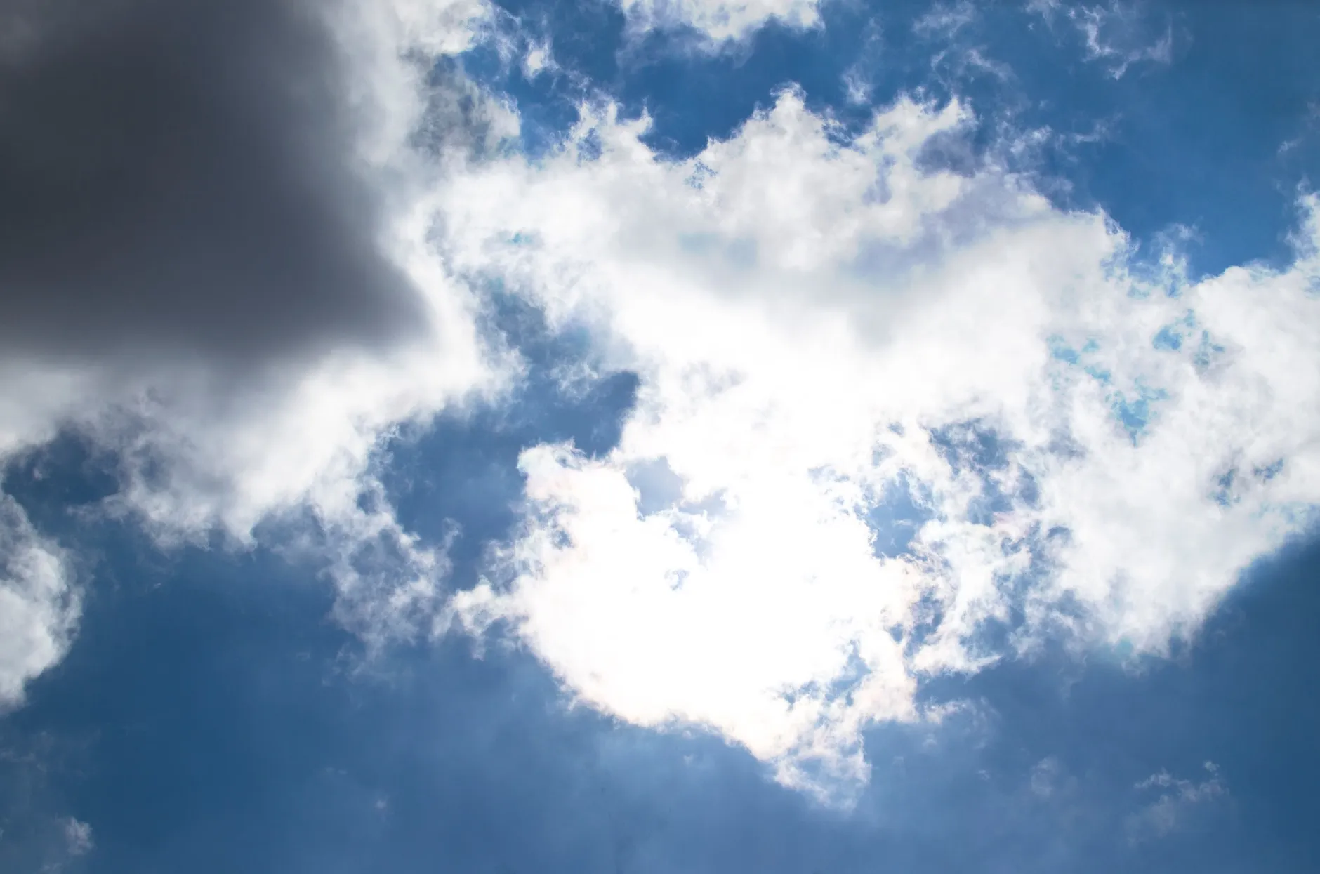 En farverig skyhimmel med fluffy skyer mod en dybblå himmel på en solrig dag. Billedet fanger stemningen i naturens farvespil.
