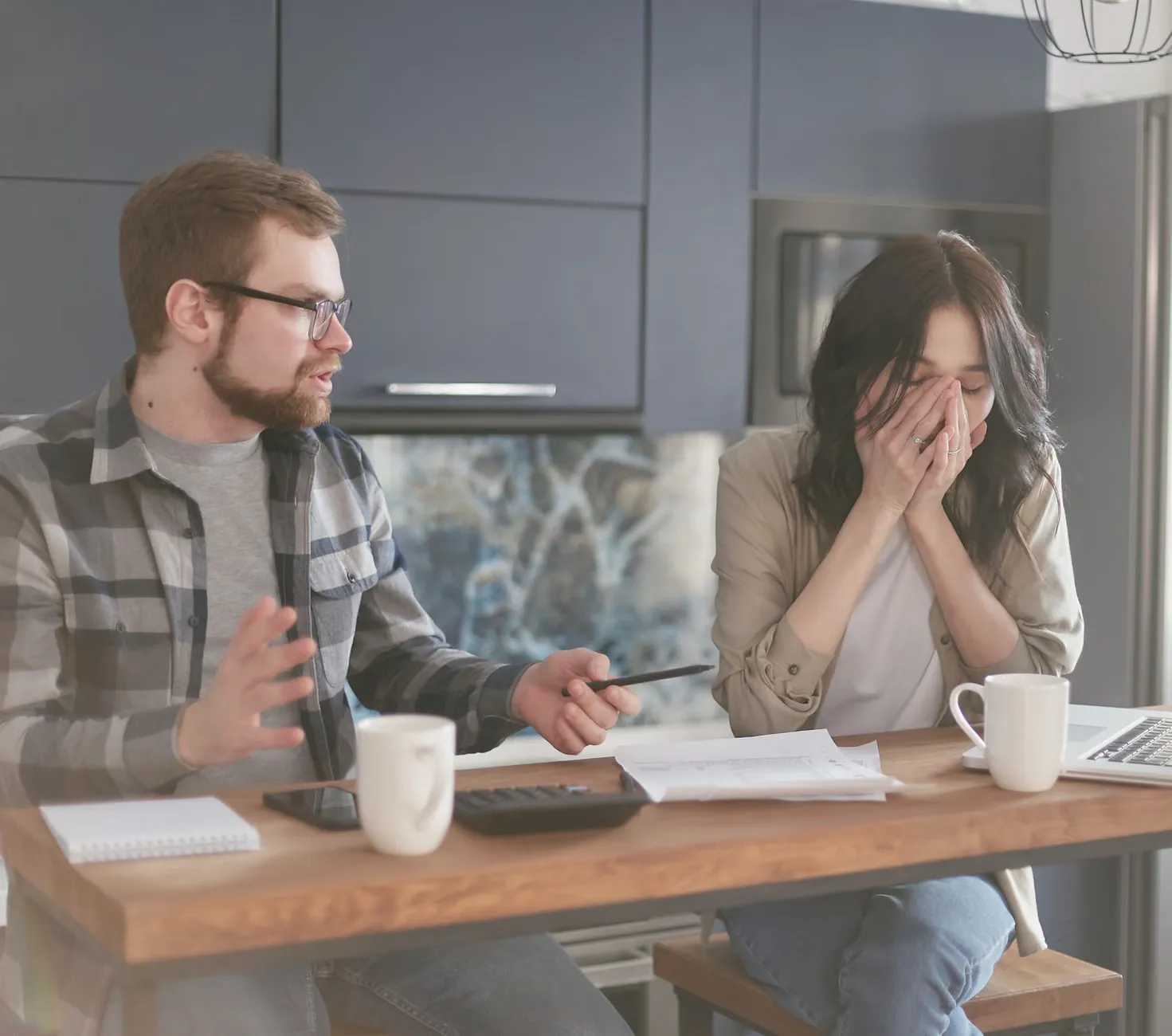 A couple discussing financial problems with visible frustration and worry.