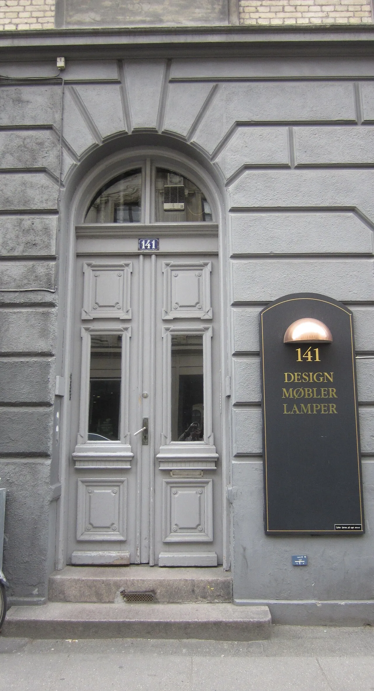 Bygningen på Gammel Kongevej 141 i København ses her i et historisk bymiljø. Et detaljepræget facadebillede med tydelig arkitektonisk karakter.