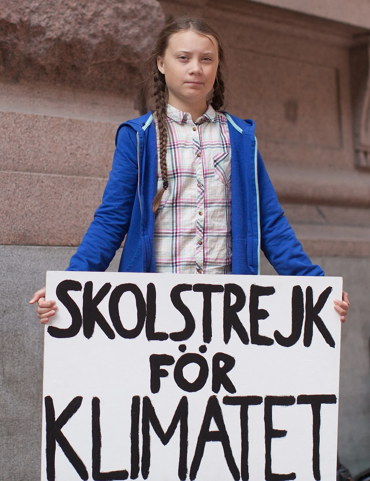 Greta Thunberg står uden for det svenske parlament og indleder en skolestrejke for klimaet. Skiltet lyder “Skolstrejk for klimatet”.