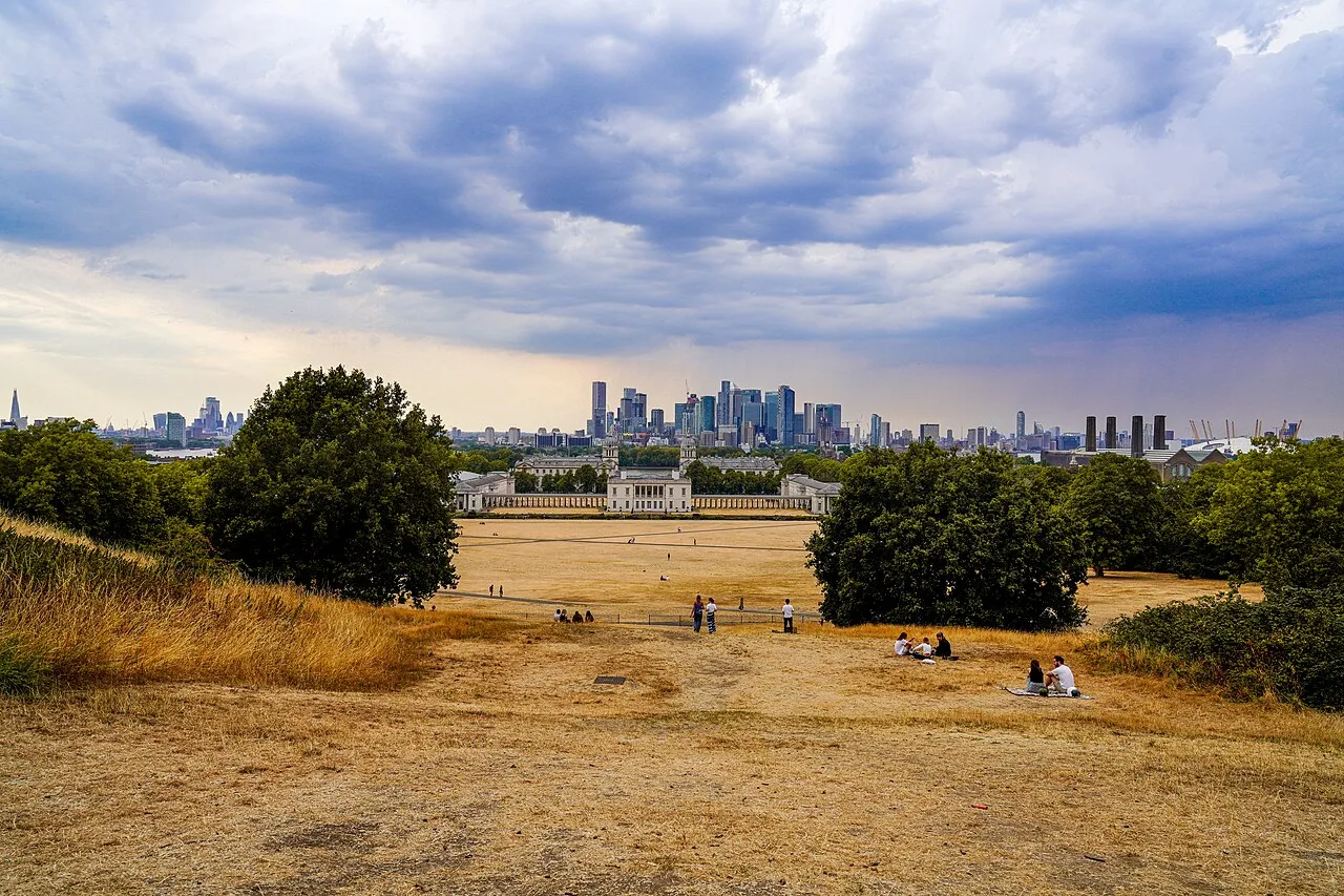 Scorched grass i Greenwich Park, London, under den intense varmebølge i august 2022. I baggrunden ses Queen's House og Canary Wharf.