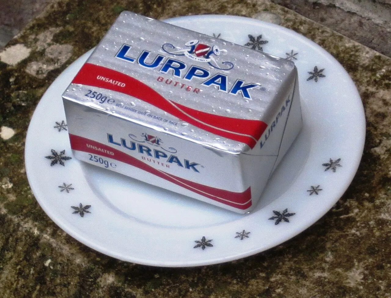 Et produktbillede af Lurpak smør 250 g usaltet. Fokus er på emballagen og produktets synlige detaljer.