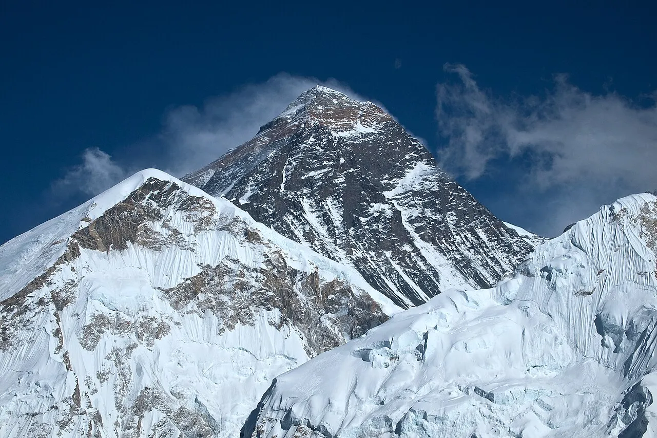 Mount Everest, verdens højeste bjerg, ses her med sne og is under en klar himmel. Billedet viser bjergmassivet i Himalaya-regionen.