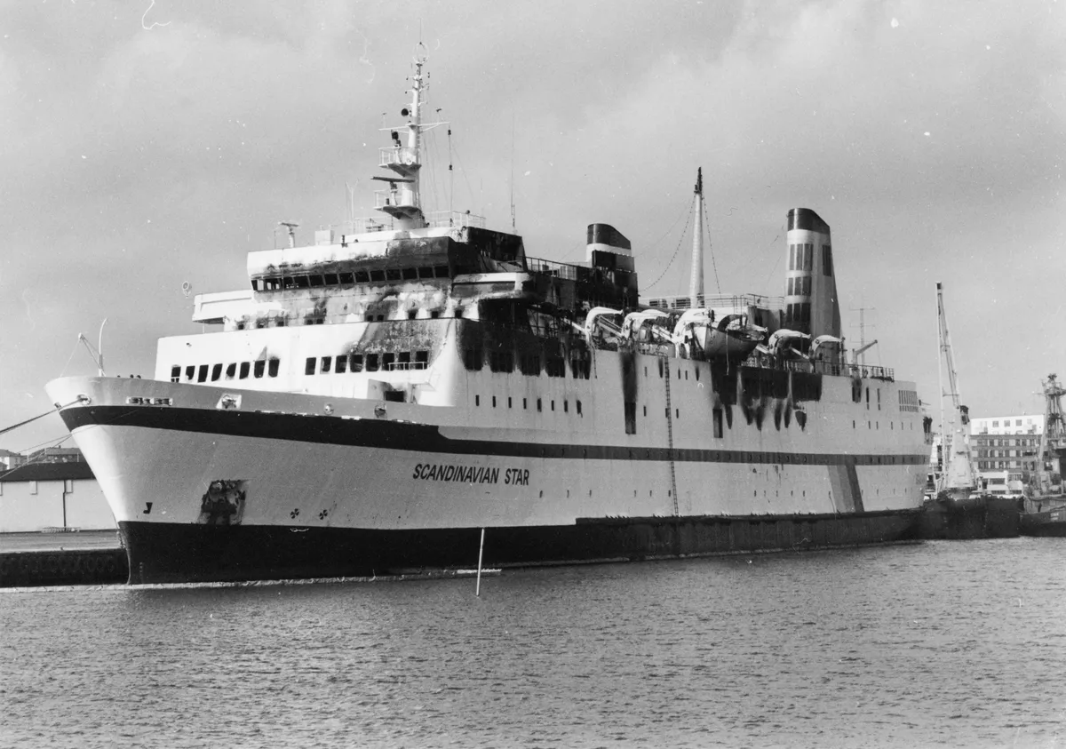 Cruisefærgen MS Scandinavian Star ligger i Lysekil havn i Sverige efter en brand under en rejse mellem Oslo og Fredrikshavn i april 1990. Brandkatastrofen kostede 157 passagerer og to besætningsmedlemmer livet.