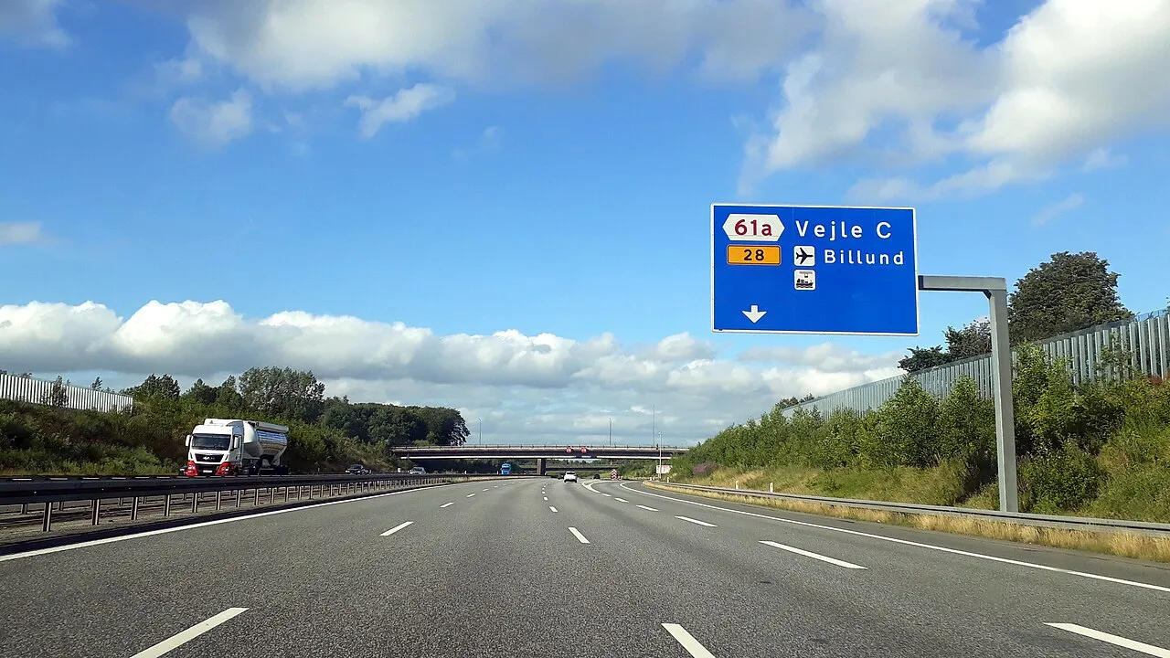 E45-motorvejen i Danmark set ved afkørsel 61a Vejle C. Billedet viser vejens infrastruktur og trafikmiljøet i området.