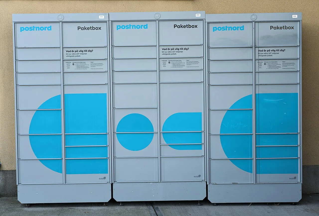 En PostNord pakkeboks placeret i en gade. Billedet viser boksen som en del af byens infrastruktur.