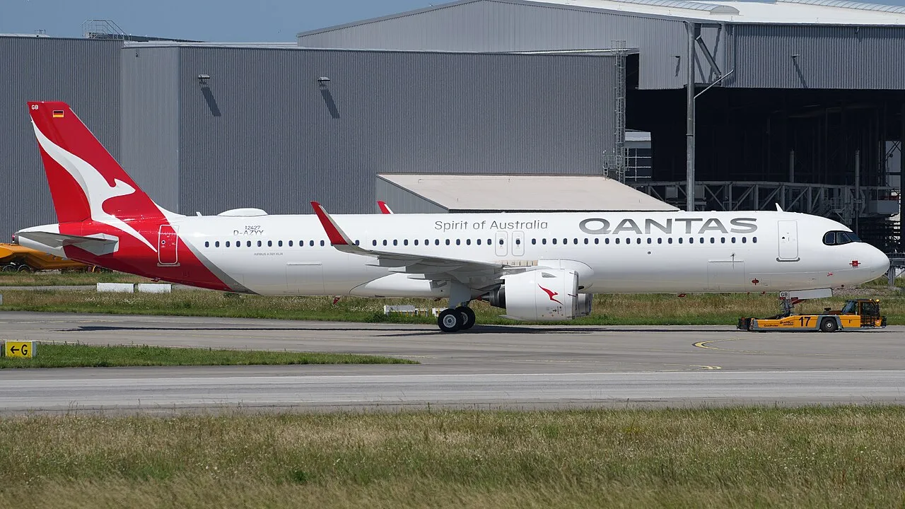 En Qantas Airways Airbus A321-271NY XLR med registrering VH-OGB bliver bugseret over flyvepladsen ved Hamburg-Finkenwerder. Billedet viser flyet i forbindelse med ground handling.
