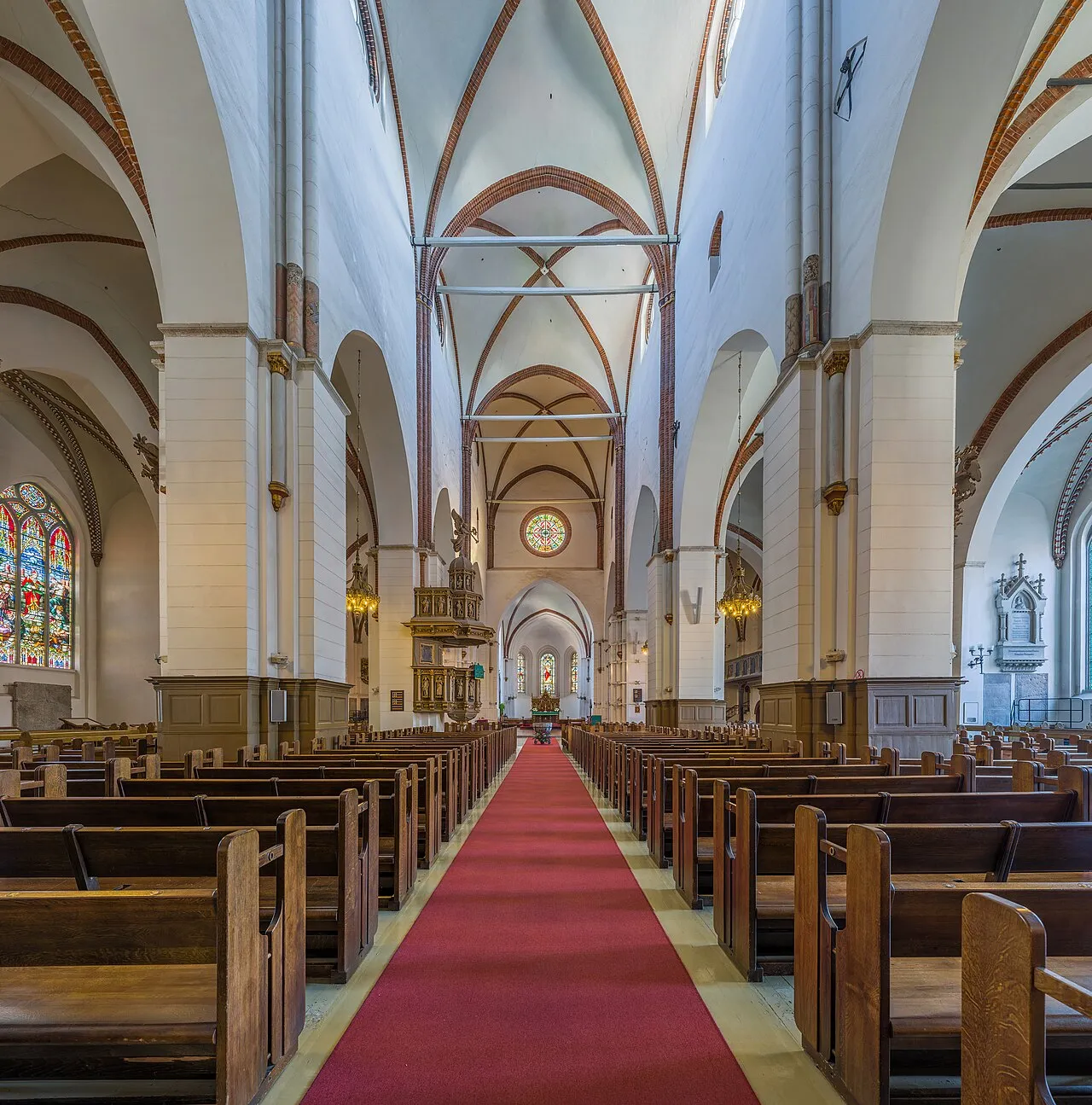 Indvendigt syn i Riga Domkirke med fokus på kirkens lange skib. Stemningen er præget af arkitektur og lys i rummet.