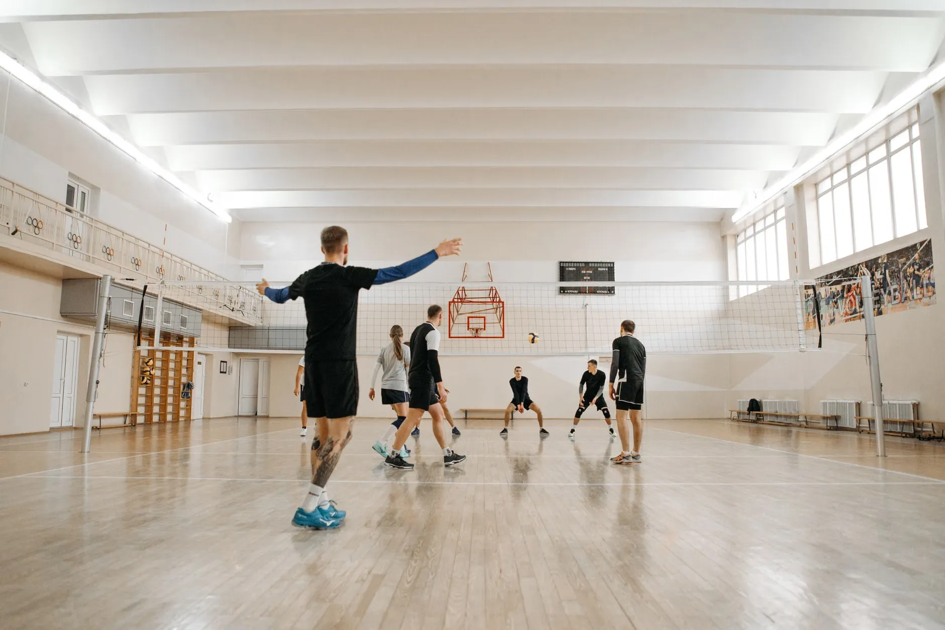 En energisk volleyballtræningssession med en blandet hold indendørs. Perfekt til sportsrelaterede temaer.
