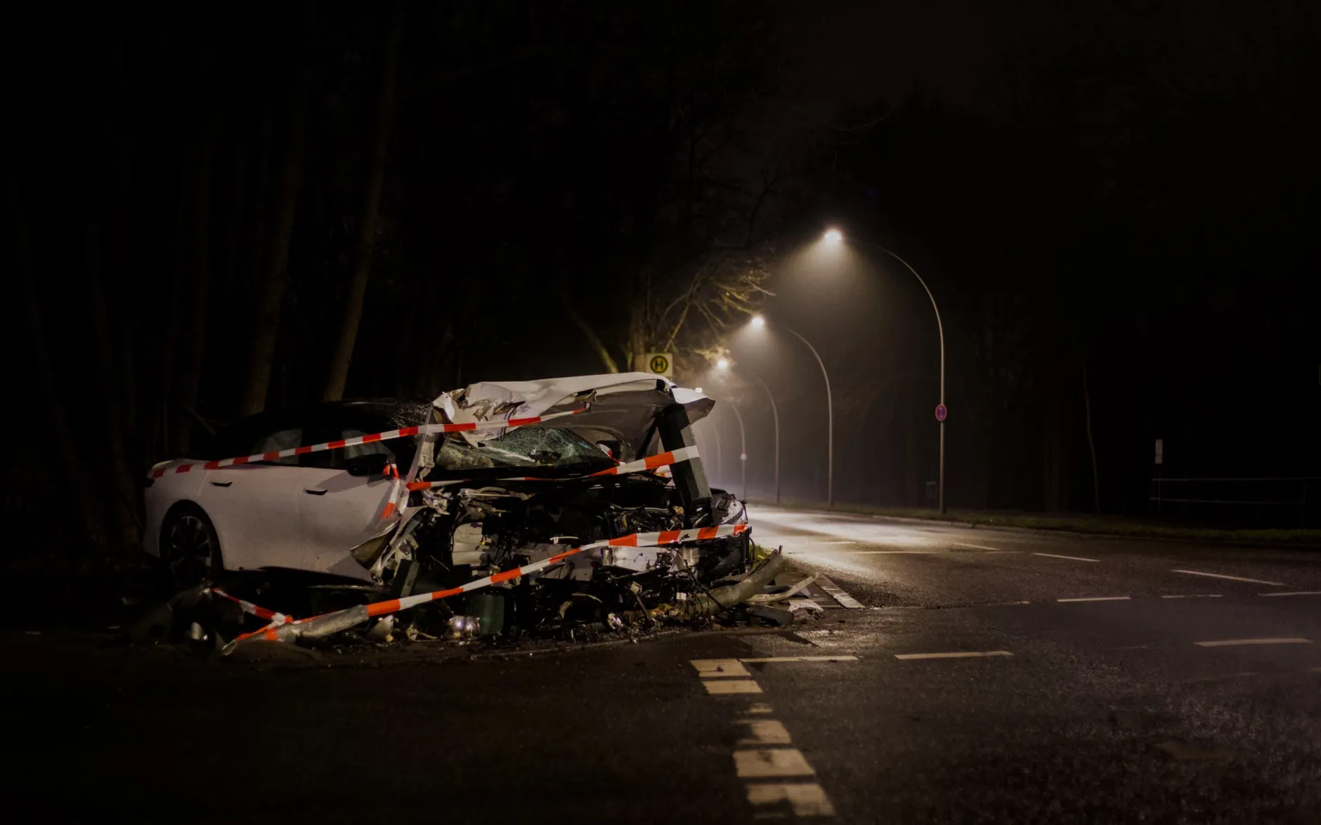 En rød bil er væltet over på en sort bil i en udendørs scene. Billedet viser et dramatisk øjeblik fra en bilkrasch.