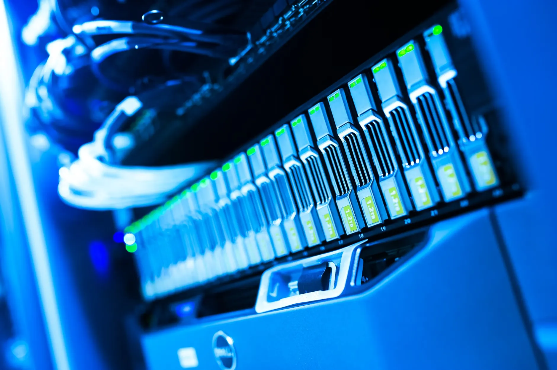 Et detaljeret billede af et blåbelyst serverrack i et datacenter, der viser den tekniske og hardwaremæssige side af datalagring.