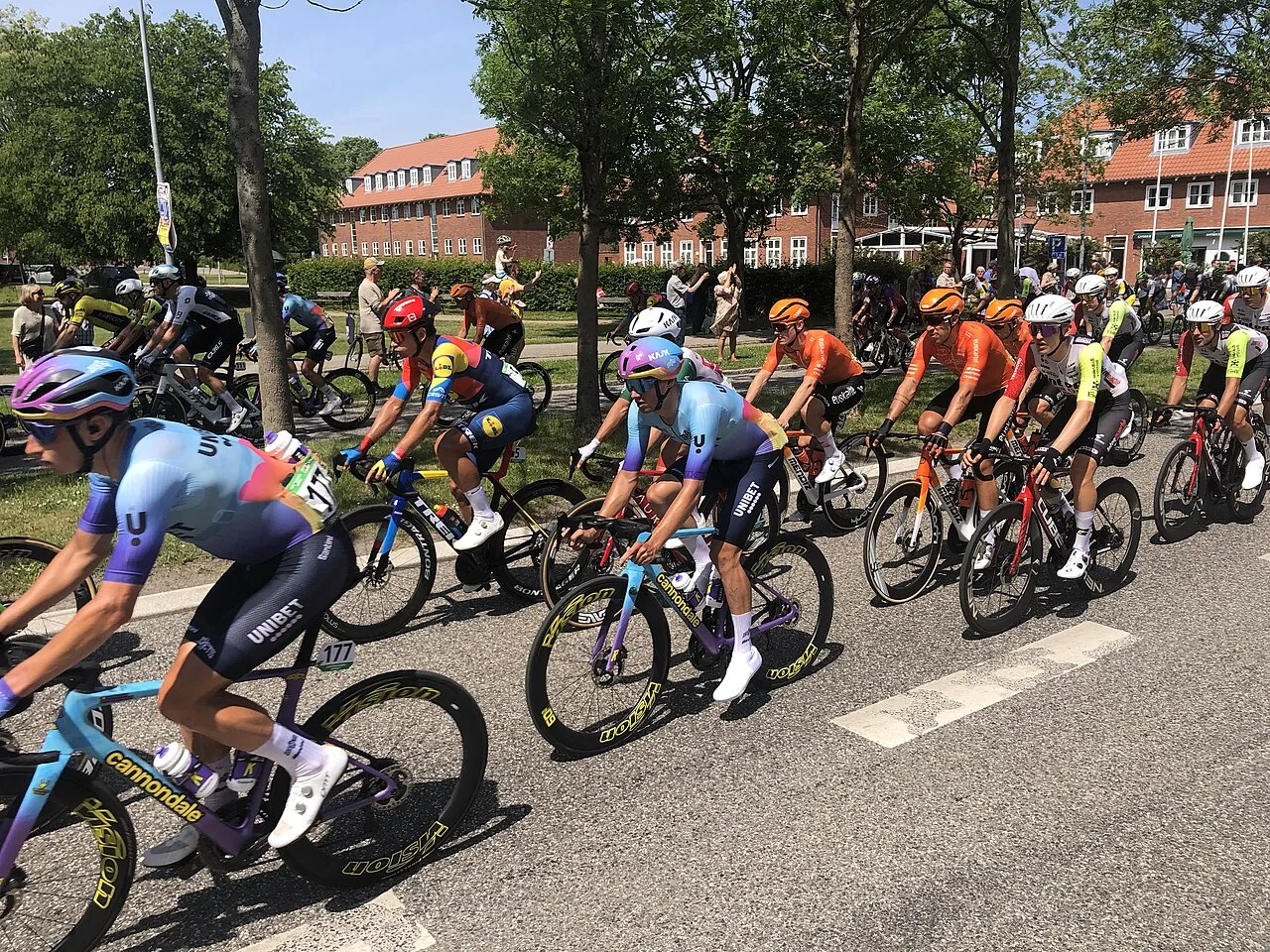 Pelotonen passerer gennem Humlebæk under mændenes 2025 Copenhagen Sprint. Billedet fanger rytterne i høj fart på ruten.