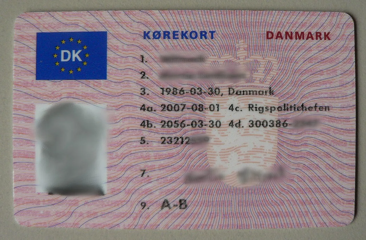 Et dansk kørekort med slørede personoplysninger for at beskytte indehaverens data. Billedet viser kortets layout uden at fremhæve navn og registreringsnumre.