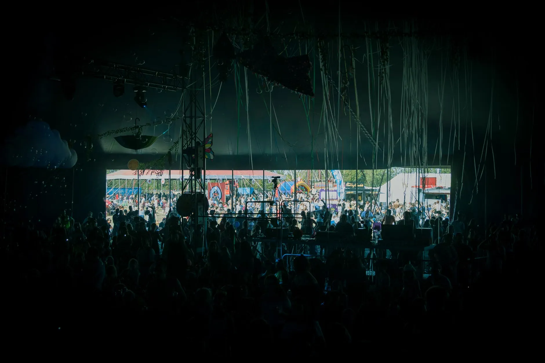 En crowd nyder live musik på en farverig udendørs festival scene. Et glædeligt øjeblik fra en sommerfestival.