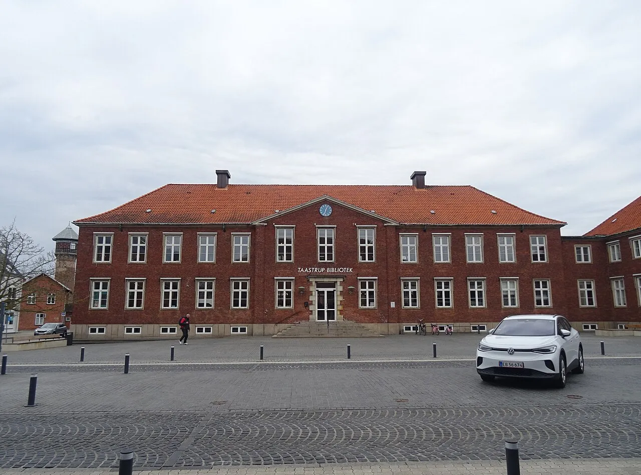 En kriminalteknisk team undersøger en forbrydelsesscene i forstaden med politibetjente og bevismarkører.