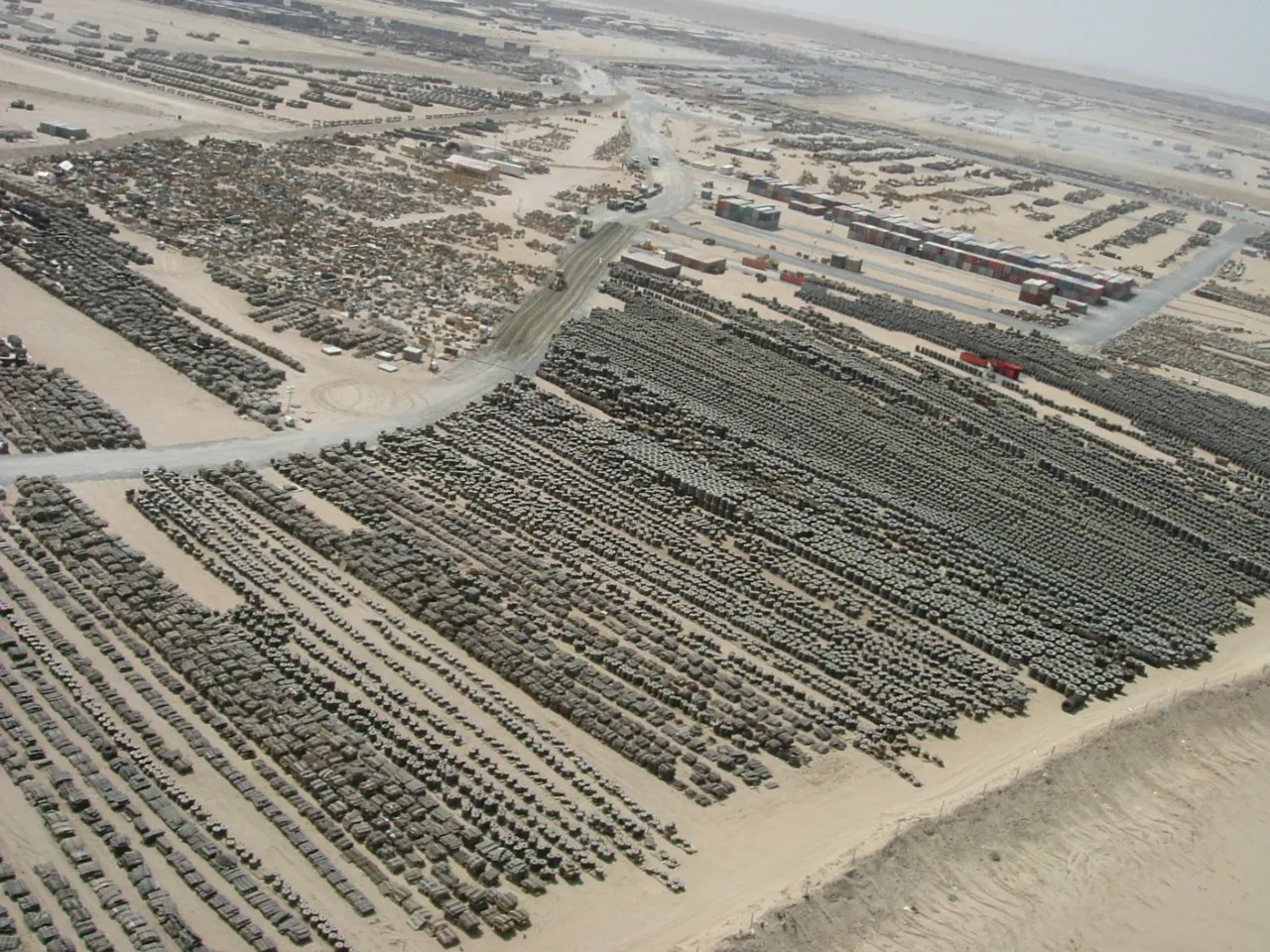 Tusindvis af dæk og andet udstyr på en opbevaringsplads på Camp Arifjan i Kuwait. Stort set alle køretøjer og kampudstyr, der losses fra MSC-skibe i Port of Ash Shuaybah, gør holdt på Camp Arifjan, før de sendes til deres endelige destination i Mellemøsten.