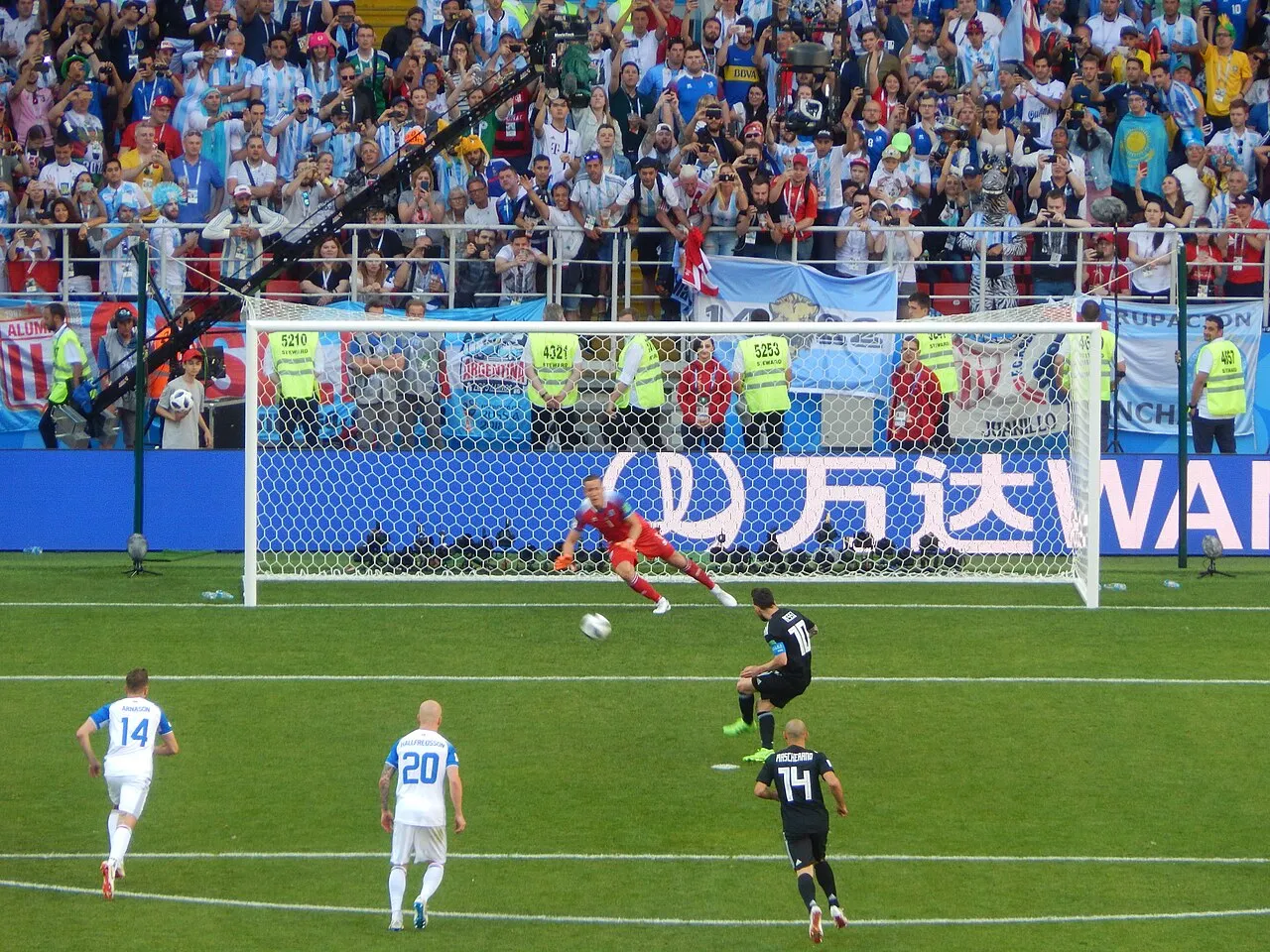 Lionel Messi scorer på straffespark under VM 2018. Billedet viser øjeblikket, hvor Messi løfter bolden mod mål.