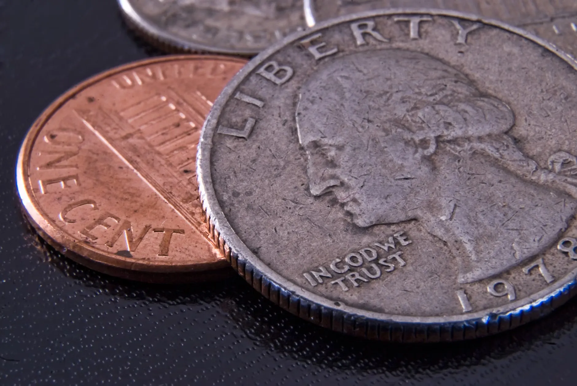 Detaljeret nærbillede af en amerikansk kvartal og en penny, der viser mønternes tekstur.