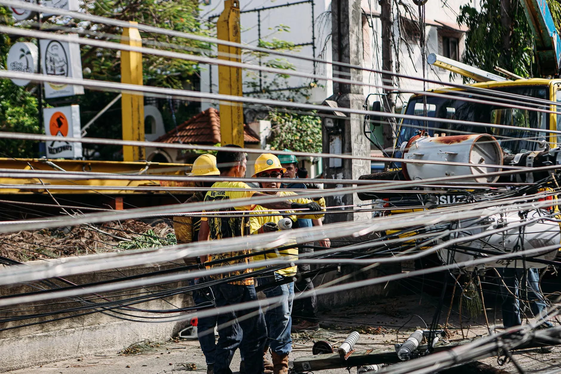 Utility-arbejdere reparerer nedbrudte strømlinjer udendørs efter en større skade, der har forårsaget kaos i området.